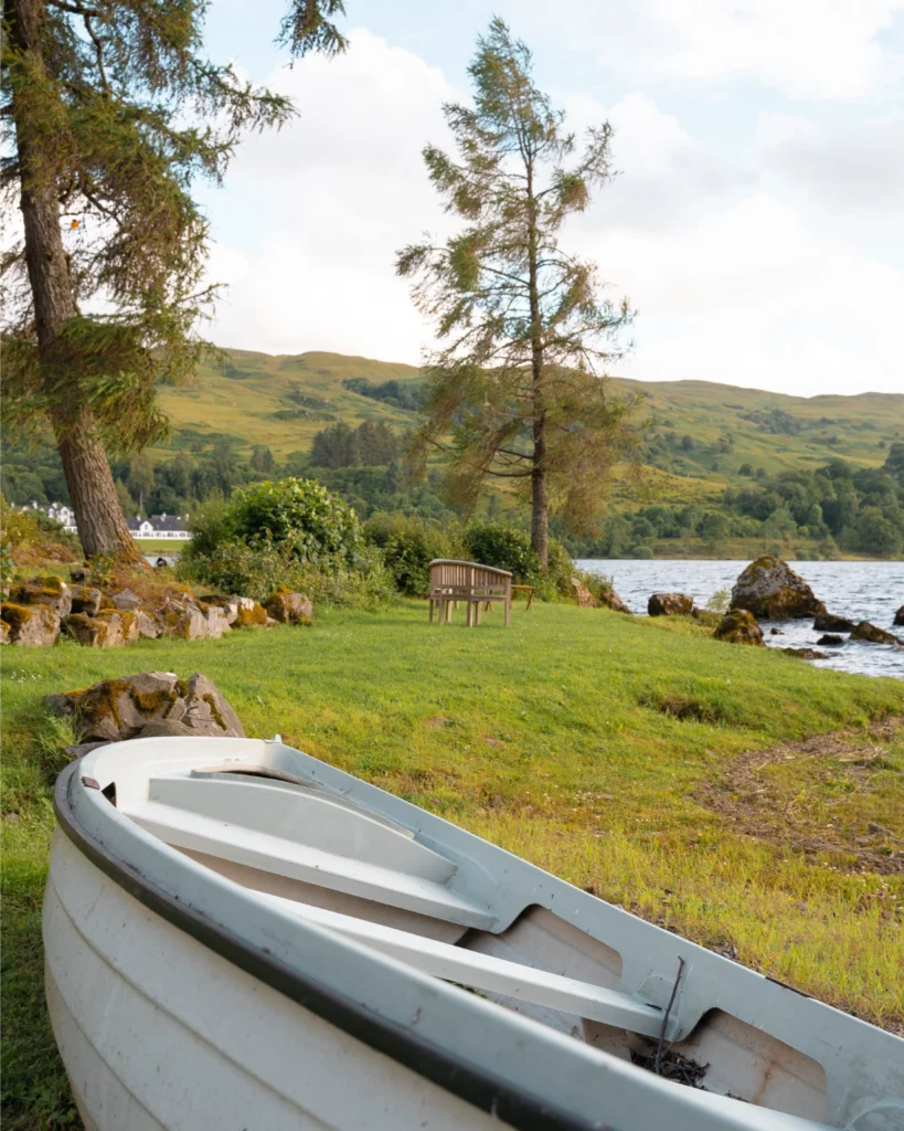 boat rests on the lawn by the loch
