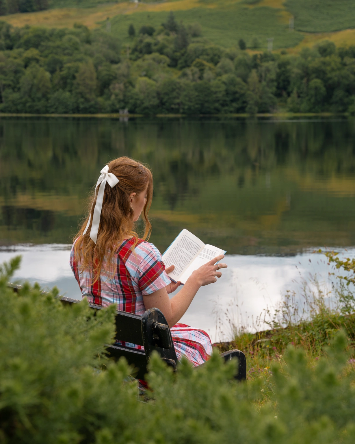 girl reads a book by the lake scotland travel