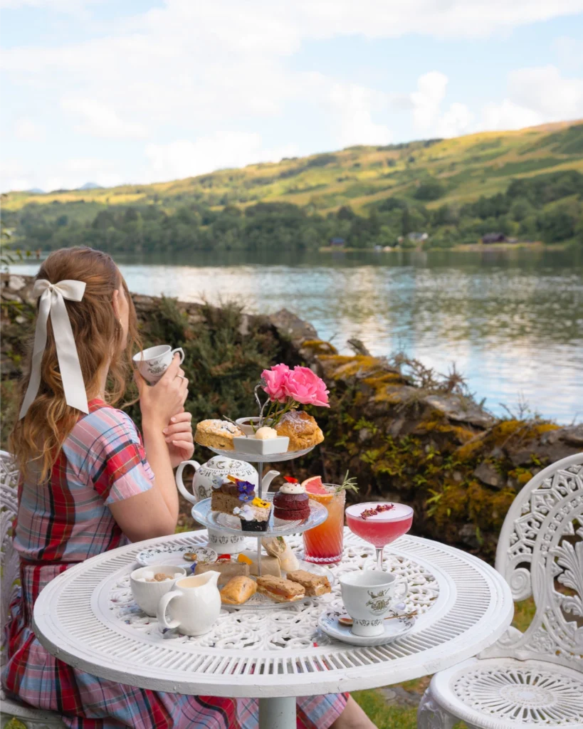 girl drinks tea by a beautiful lake