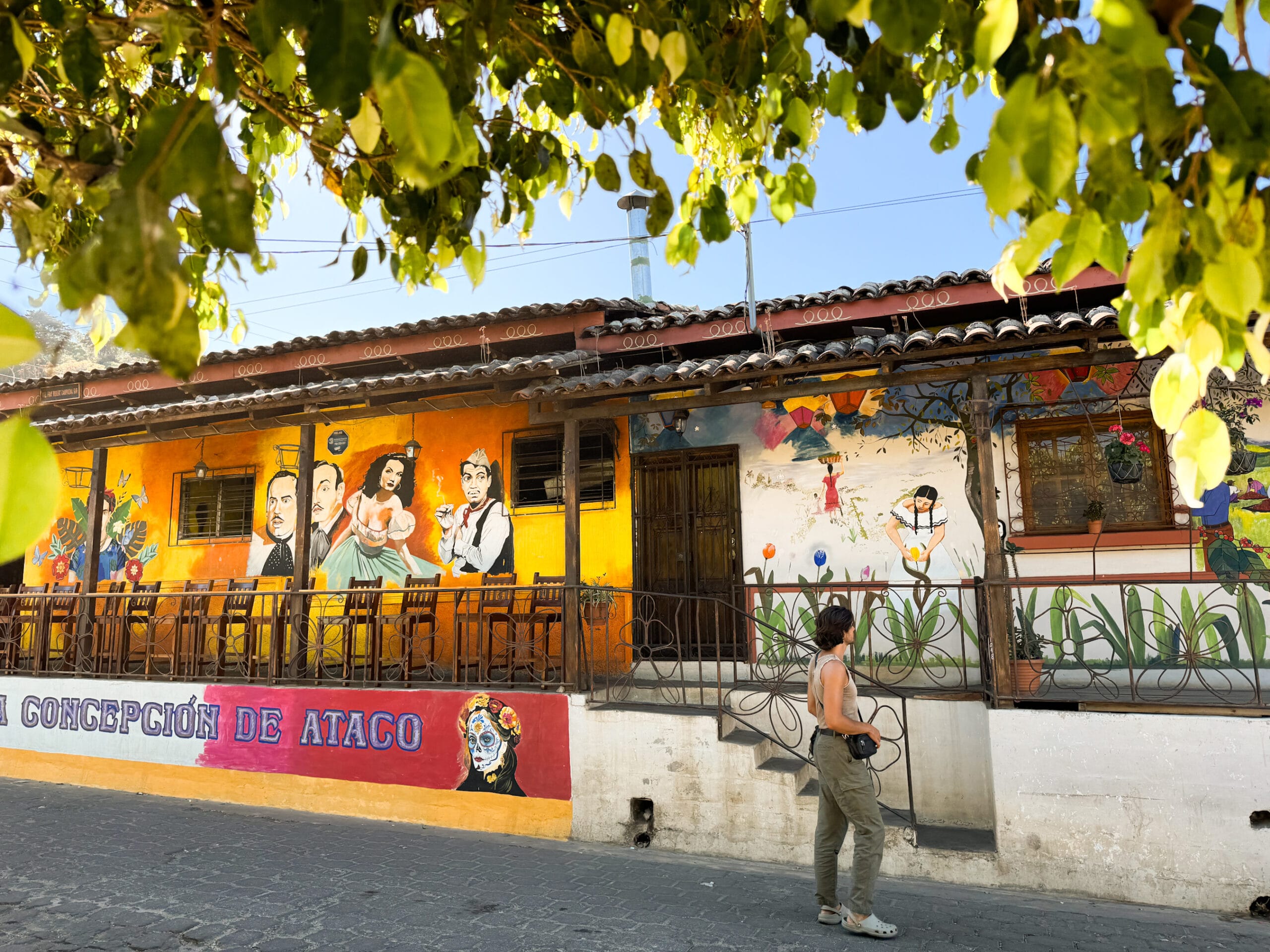 man walks down colourful painted street in el salvador