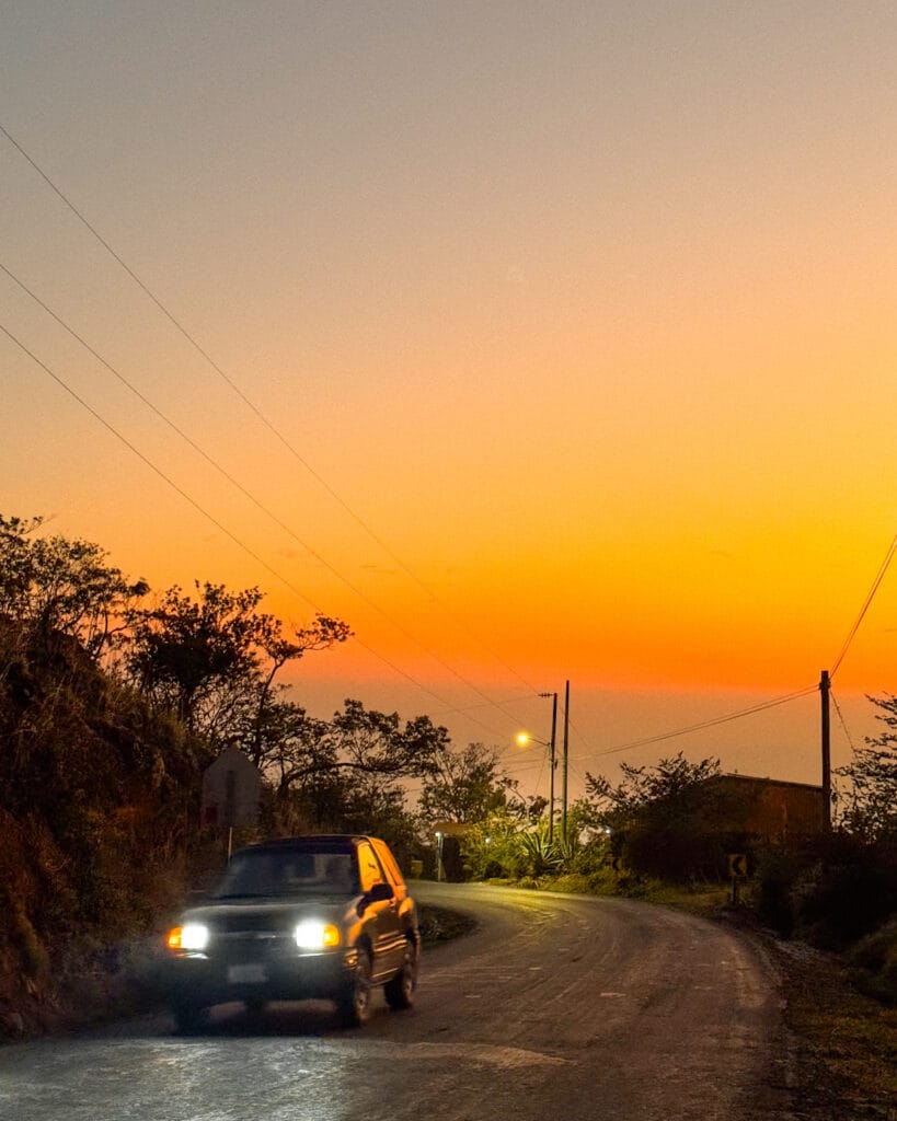 costa rica travel sunset in monteverde mountains with car headlights